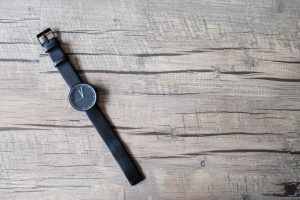 Minimal black watch on artificial wood background